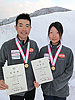 [写真]メダルと賞状を持つ新田佳浩選手と太田渉子選手