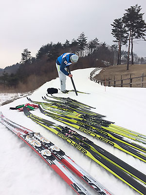 [写真]グリップワックスをかける佐藤勇治コーチ