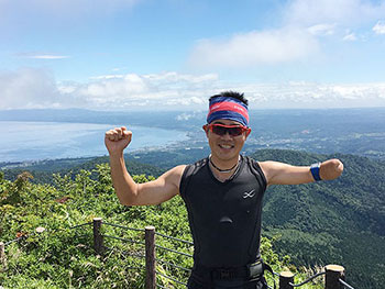 [写真]海の見える山頂に立つ新田佳浩選手