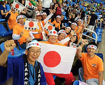 [写真]久保選手5000m予選開始前、応援の旗を持ったアウローラ応援団