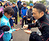 [写真]子供たちにリオパラリンピック記念コインを配る久保恒造選手