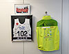 [写真]株式会社TACホールディングス様の応接室に飾られたワールドカップ旭川大会のボランティアジャケットとビブ、ソチパラリンピック日本代表チームの記念写真