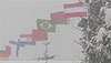 [写真]吹雪ではためく各国の国旗
