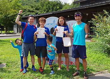 [写真]賞状を持った新田、阿部、川除選手、長濱コーチ、新田選手の子供たち