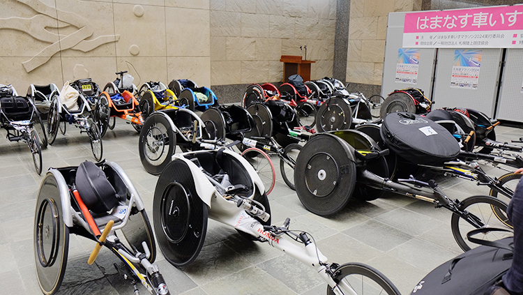 [写真]車いす陸上のレーサーがずらりと