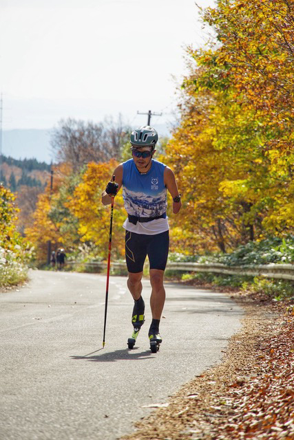 [写真]色づいた紅葉の中をローラーで通過する新田選手