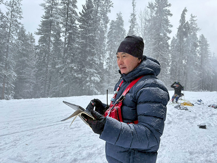 [写真]コース脇で選手の仕上がりを見つめる長濵