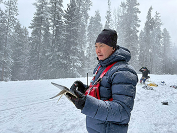 [写真]コース脇で選手の仕上がりを見つめる長濵