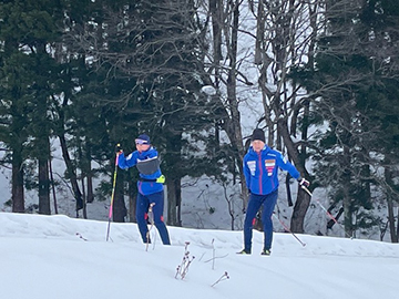 [写真]阿部選手の脇でサポートしながら滑る