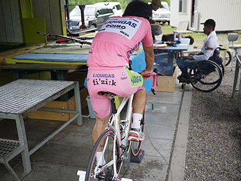 [写真]自転車のローラーで心拍を上げる佐藤選手