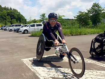 [写真]車いすレーサーに乗る長田弘幸