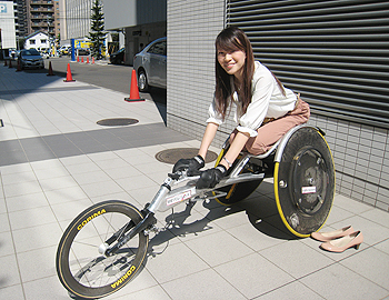 [写真]長田弘幸選手のレーサーに乗るエリコさん