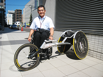 [写真]長田弘幸選手とレーサー（競技用車いす）