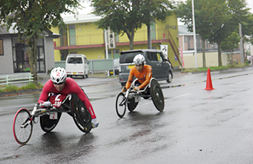[写真]雨の中車いすマラソンレース中の久保恒造選手